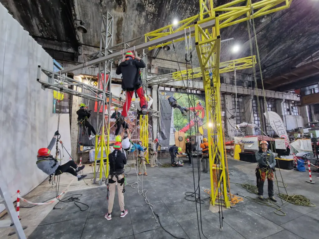 Busy indoor rope access training session with multiple trainees on ropes