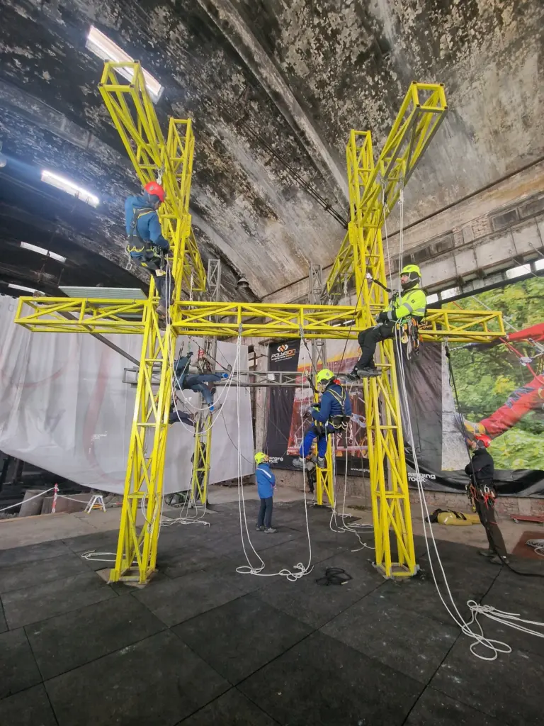 Trainees working on the tall yellow rope access training structure