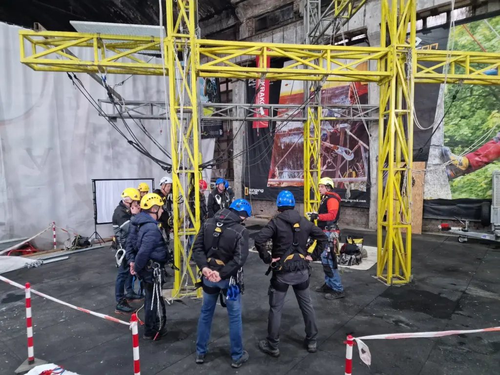 Rope access trainees climbing and positioning on the yellow structure